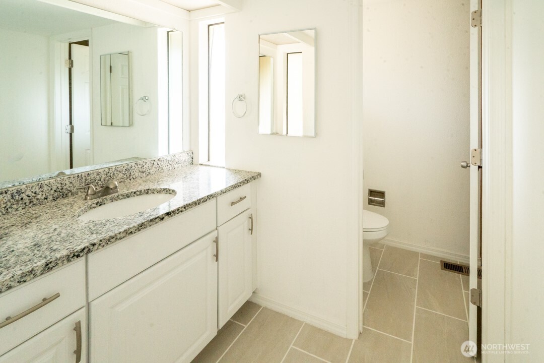 529 Southwest 324th Street Federal Way, WA 98023 - Photo 12 of 22 a bathroom with a granite countertop sink and a mirror