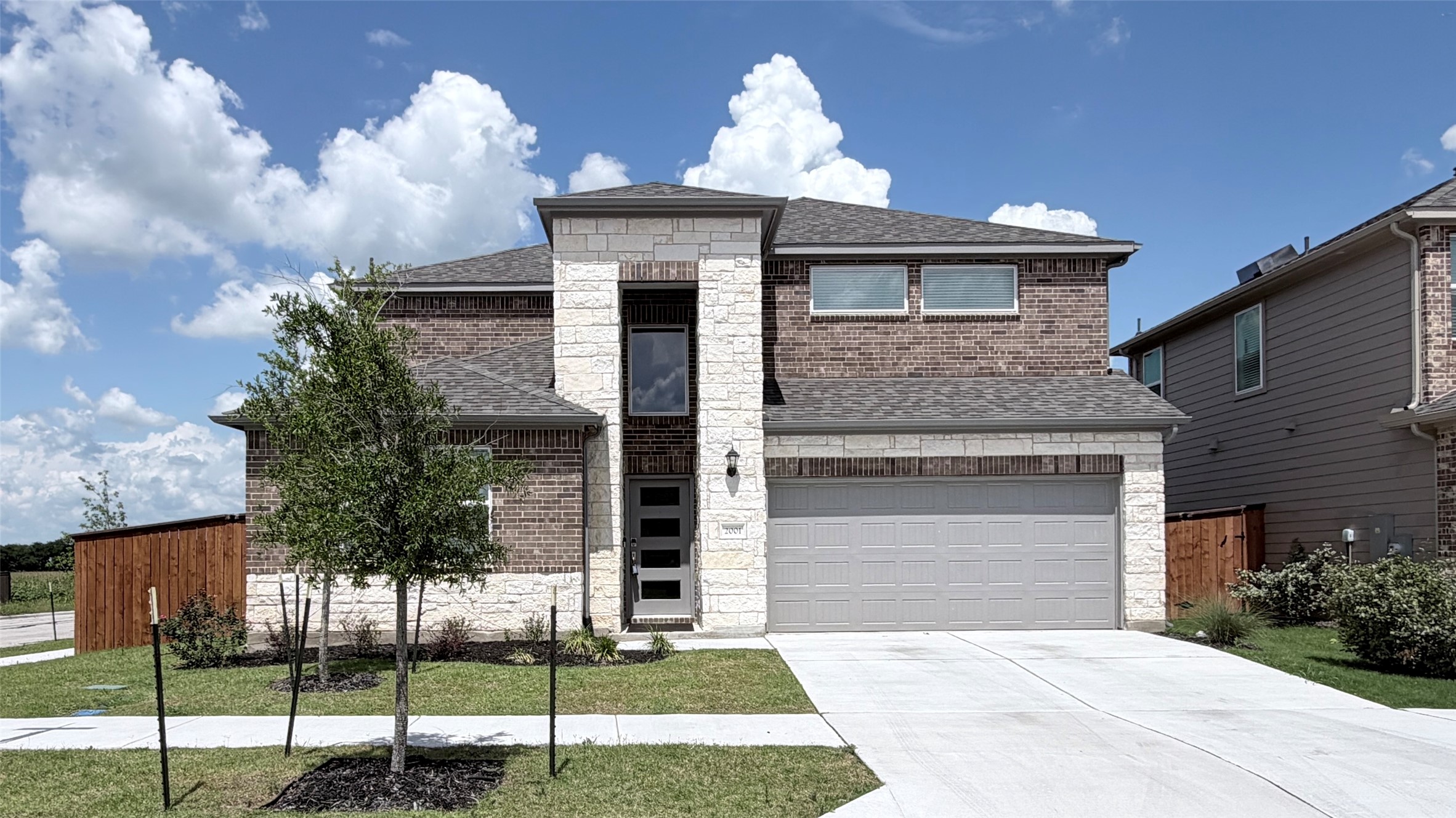 2001 Wynn Road Hutto, TX 78634 - Photo 2 of 39 A well-maintained facade combines brick and stone with a two-car garage and verdant landscaping.