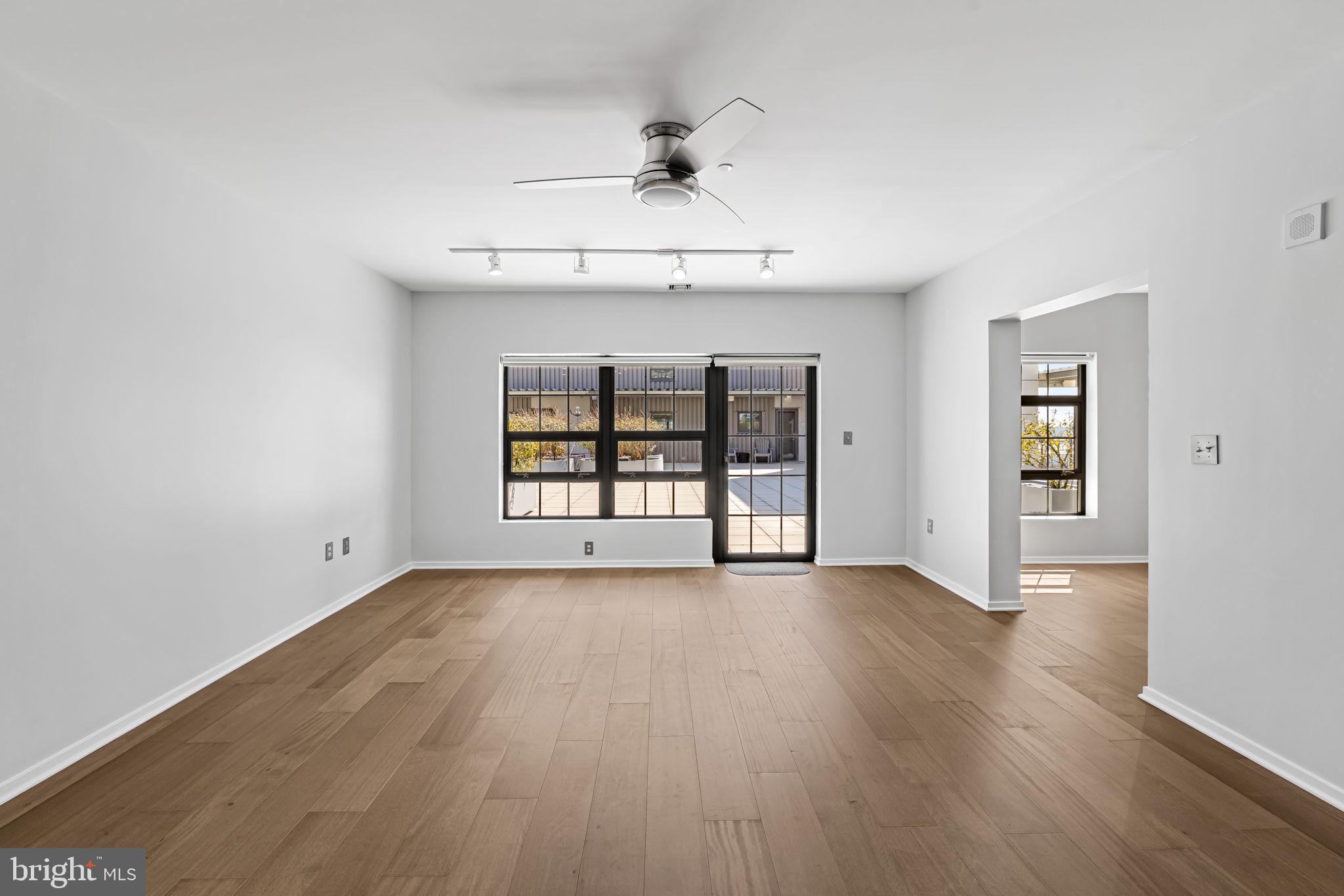 1200 Steuart Street, Unit 1035 Baltimore, MD 21230 - Photo 12 of 96 an empty room with wooden floor chandelier and windows
