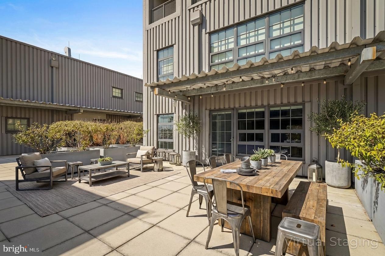 1200 Steuart Street, Unit 1035 Baltimore, MD 21230 - Photo 17 of 96 a view of a patio with couches table and chairs and potted plants