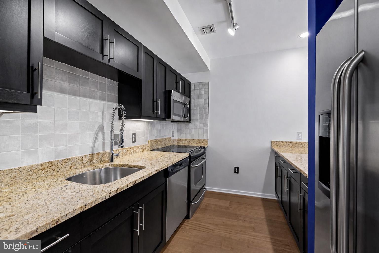 1200 Steuart Street, Unit 1035 Baltimore, MD 21230 - Photo 22 of 96 a kitchen with stainless steel appliances granite countertop a sink stove and refrigerator