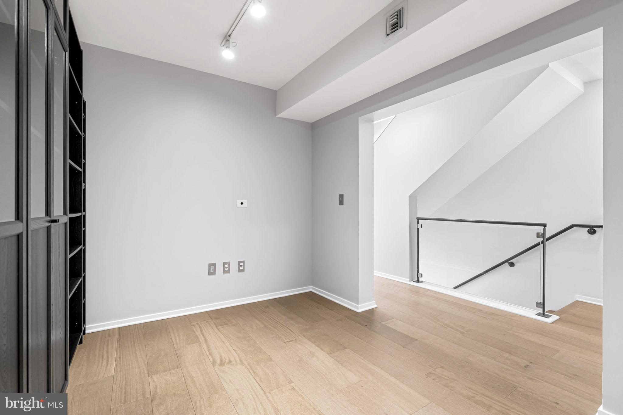 1200 Steuart Street, Unit 1035 Baltimore, MD 21230 - Photo 30 of 96 an empty room with wooden floor and windows