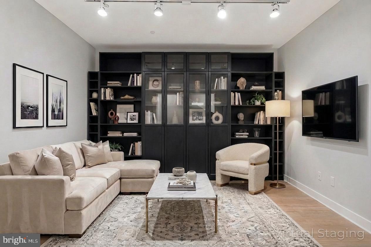 1200 Steuart Street, Unit 1035 Baltimore, MD 21230 - Photo 32 of 96 a living room with furniture a flat screen tv and a bookshelf