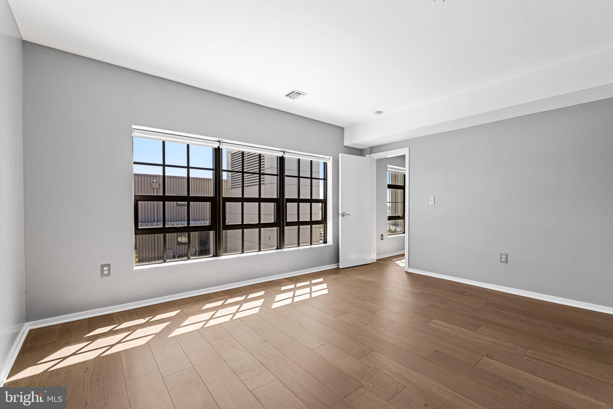 1200 Steuart Street, Unit 1035 Baltimore, MD 21230 - Photo 38 of 96 a view of an empty room with a window and wooden floor