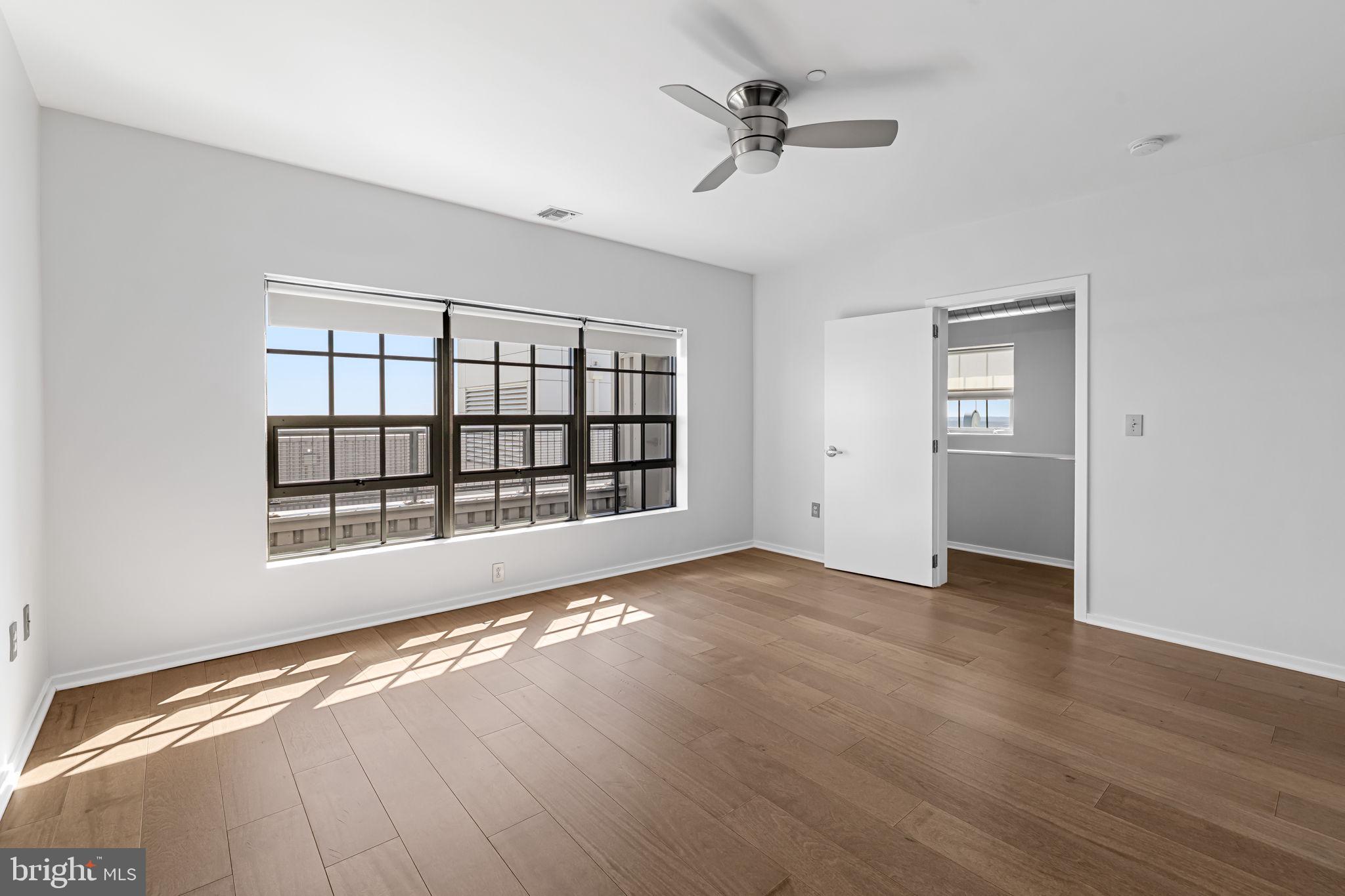 1200 Steuart Street, Unit 1035 Baltimore, MD 21230 - Photo 51 of 96 a view of an empty room with a window and wooden floor