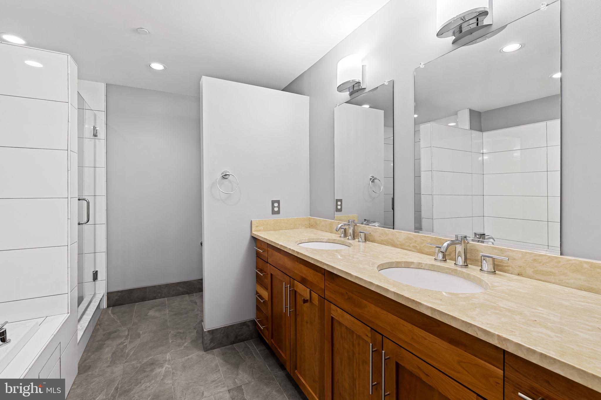 1200 Steuart Street, Unit 1035 Baltimore, MD 21230 - Photo 56 of 96 a spacious bathroom with a granite countertop sink mirror and double