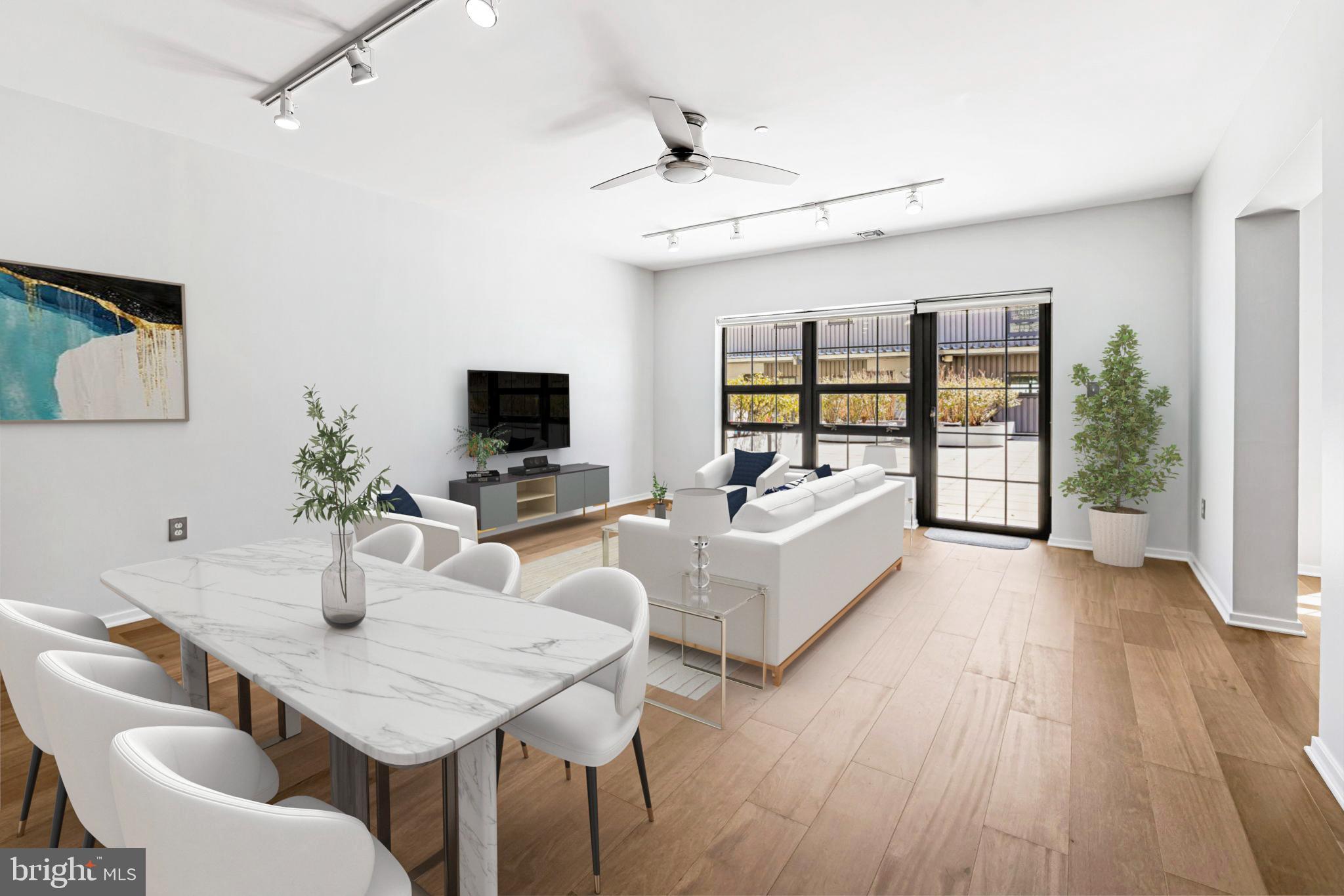 1200 Steuart Street, Unit 1035 Baltimore, MD 21230 - Photo 6 of 96 a living room with furniture a flat screen tv and a floor to ceiling window