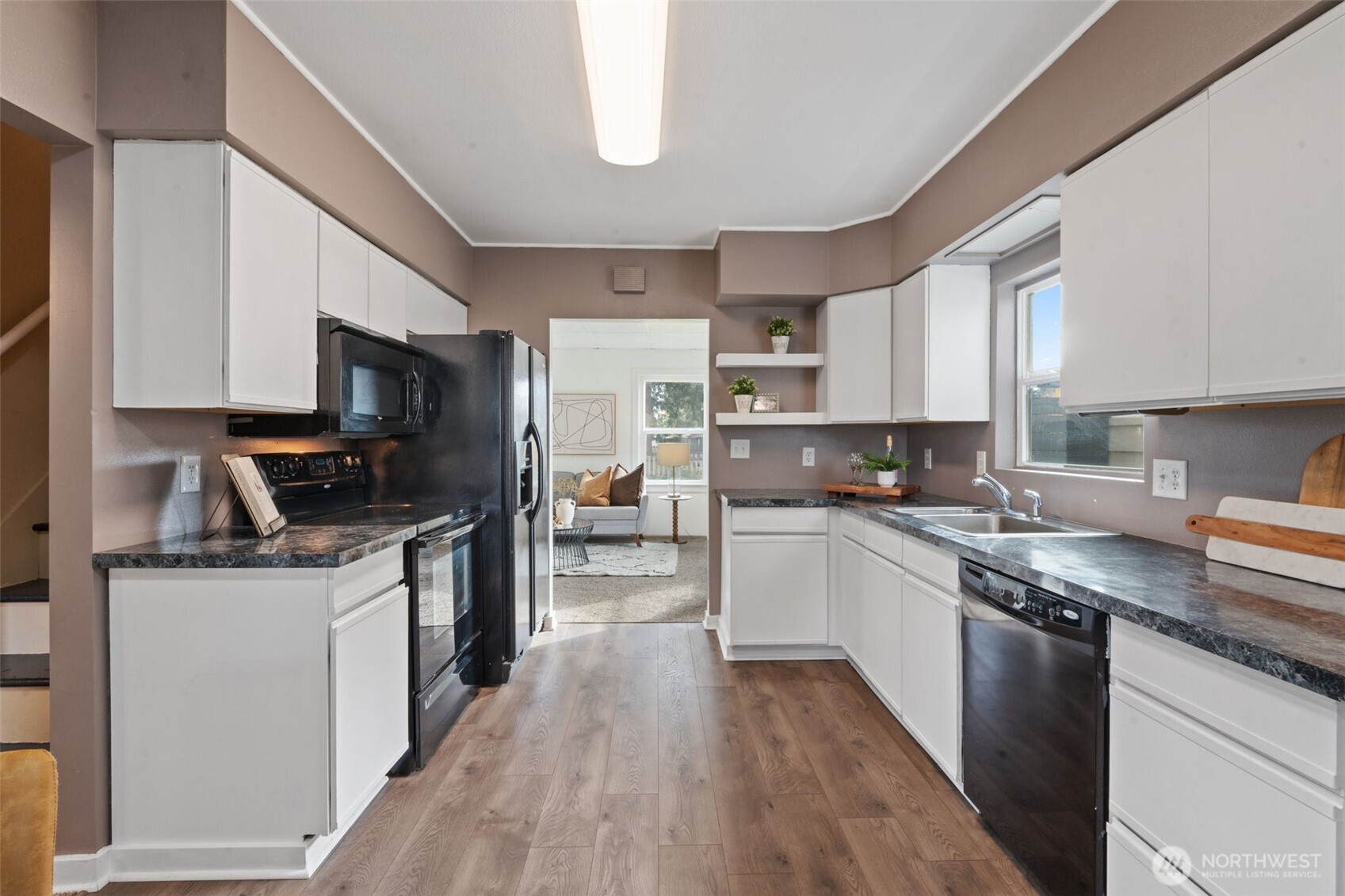 2403 34th Avenue Longview, WA 98632 - Photo 15 of 40 a kitchen with kitchen island granite countertop a sink wooden floor and stainless steel appliances