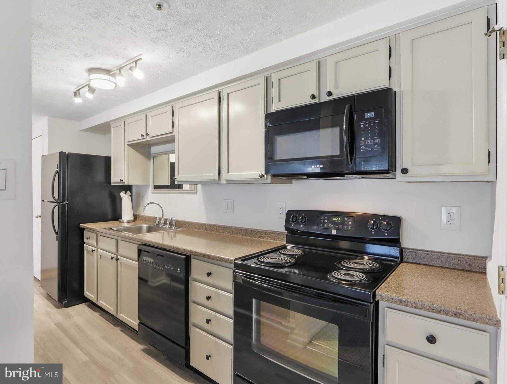 697 Deering Road, Unit 5A Pasadena, MD 21122 - Photo 13 of 24 a kitchen with stainless steel appliances granite countertop a stove a microwave and a refrigerator