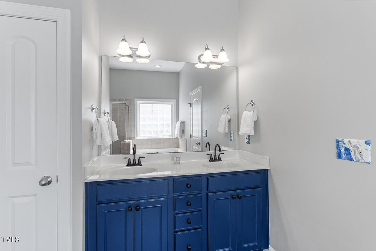 1337 Formal Garden Way Raleigh, NC 27603 - Photo 23 of 36 a bathroom with double vanity sinks a vanity a lamp and a mirror