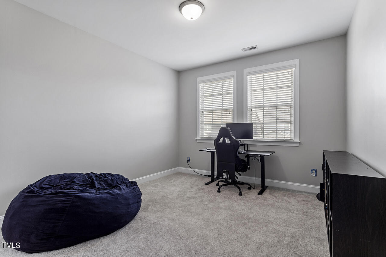 1337 Formal Garden Way Raleigh, NC 27603 - Photo 28 of 36 a room with a large window and a chair