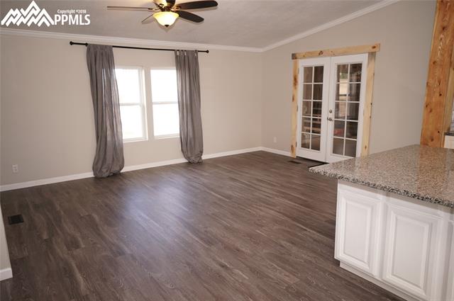 13745 Woodlake Road Elbert, CO 80106 - Photo 5 of 36 Dining room with vinyl plank flooring and french doors that lead to unfinished shell.