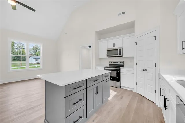 a kitchen with white cabinets and appliances