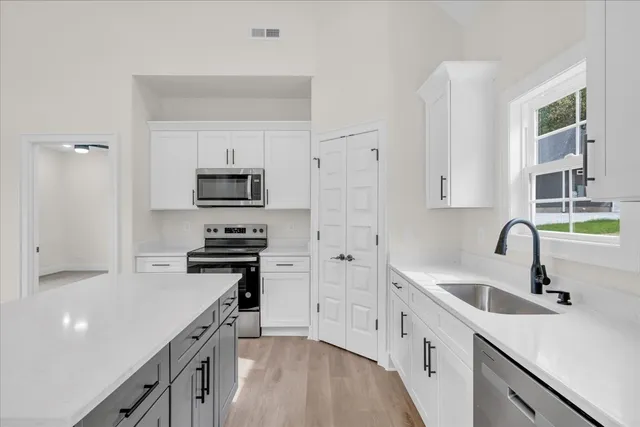 a kitchen with a sink appliances and cabinets