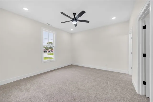 an empty room with window and ceiling fan