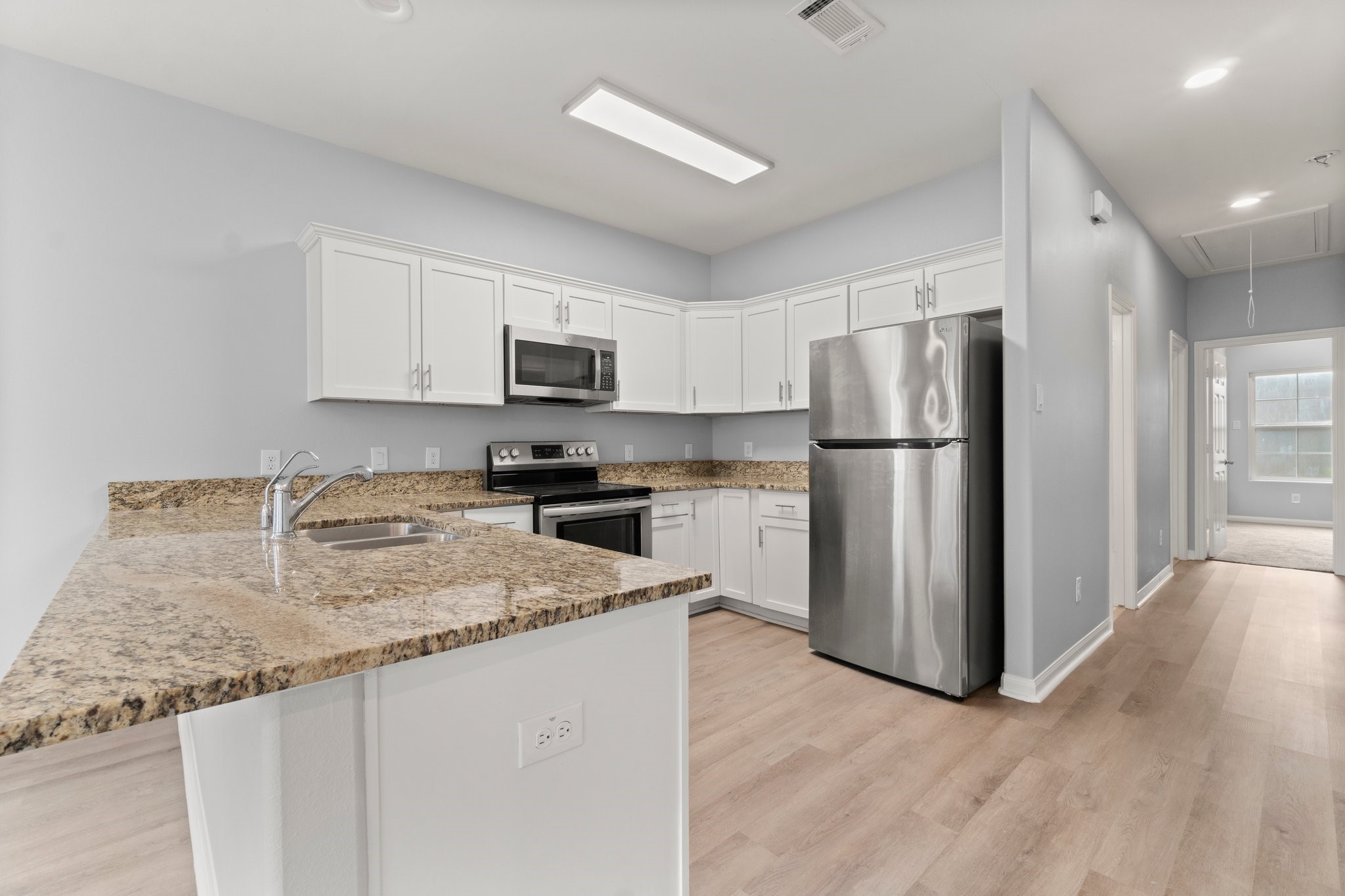 16866 West Hammon Montgomery, TX 77316 - Photo 7 of 21 a kitchen with refrigerator a microwave a sink and cabinets
