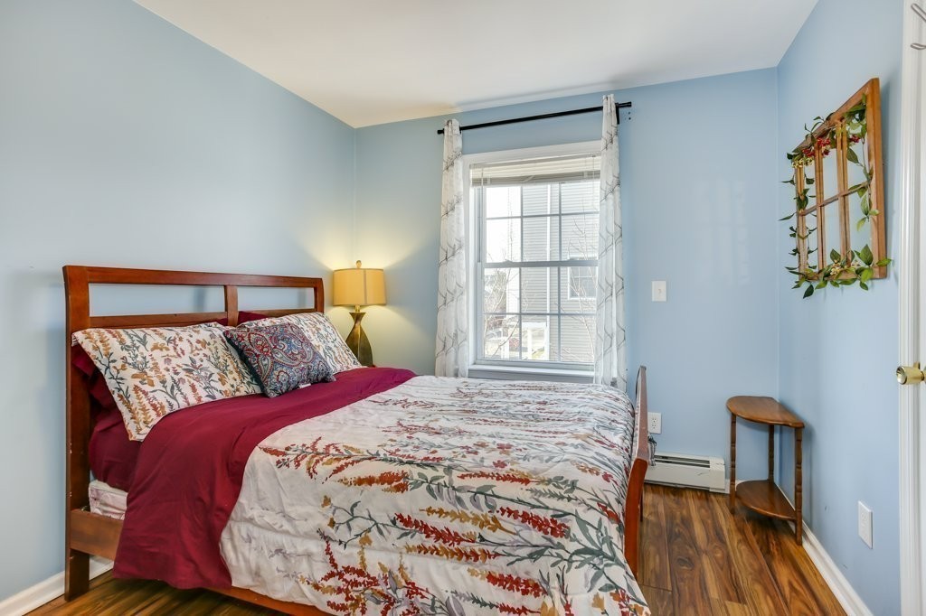 2-6 Guild Street, Unit 4 Boston, MA 02119 - Photo 10 of 20 a bed sitting in a bedroom next to a window