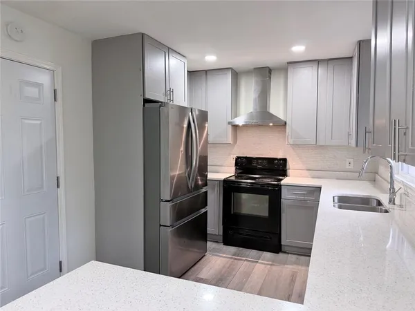 a kitchen with stainless steel appliances granite countertop a refrigerator and a sink
