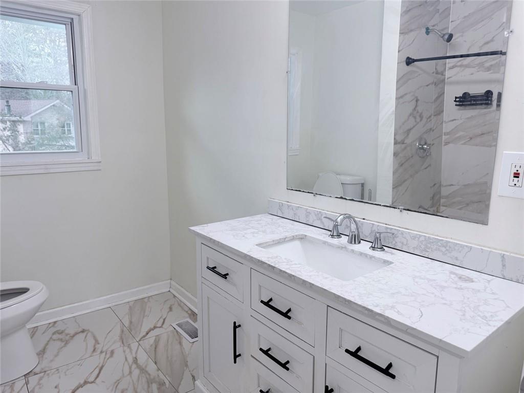 3878 Nielsen Court Clarkston, GA 30021 - Photo 15 of 26 a bathroom with a granite countertop sink mirror vanity and toilet