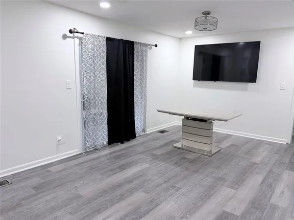 a view of a livingroom with wooden floor and a flat screen tv