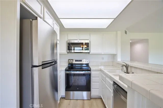 a kitchen with a sink a refrigerator and a stove top oven