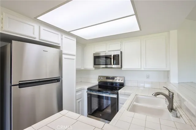 a kitchen with stainless steel appliances a refrigerator sink and microwave