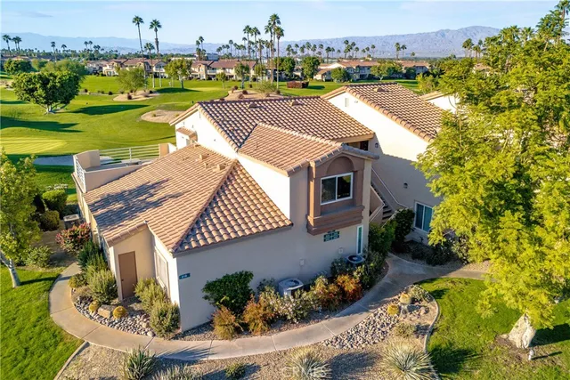 an aerial view of a house with a garden and lake view