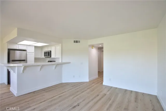 a view of kitchen with wooden floor and electronic appliances