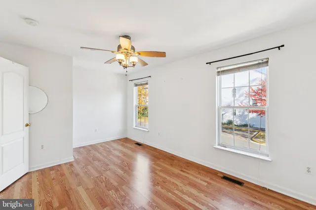 a view of a bedroom with wooden floor and a window