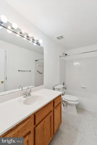 a bathroom with a double vanity sink a toilet and a mirror