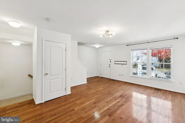 an empty room with wooden floor and window
