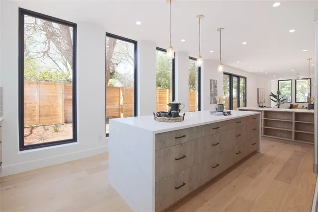 a bathroom with a double vanity sink a large mirror and a large window