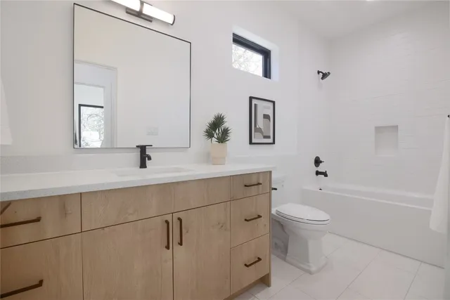 a bathroom with a toilet a sink a mirror and bathtub