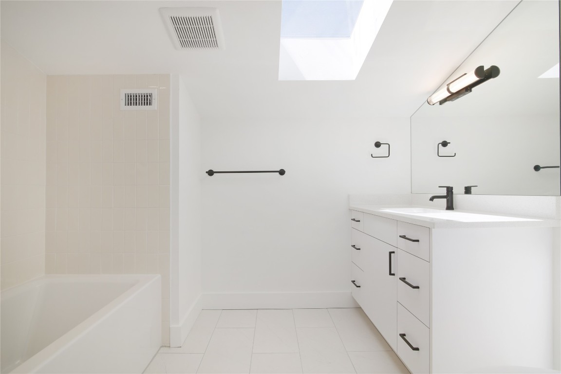 2401 Willow Street Austin, TX 78702 - Photo 26 of 38 a bathroom with a bathtub sink and mirror
