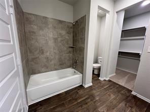 13309 Riding Drive Manor, TX 78653 - Photo 16 of 34 Full bath featuring dark wood-style floors, shower / tub combination, and a walk in closet