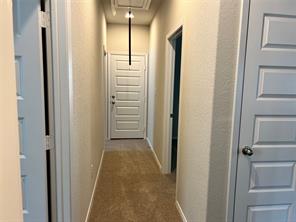 13309 Riding Drive Manor, TX 78653 - Photo 20 of 34 Hallway to primary bedroom, and 3 other bedrooms, and a full bath on the hallway that leads to the 2 car garage.