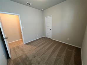13309 Riding Drive Manor, TX 78653 - Photo 25 of 34 Unfurnished bedroom with dark colored carpet and baseboards