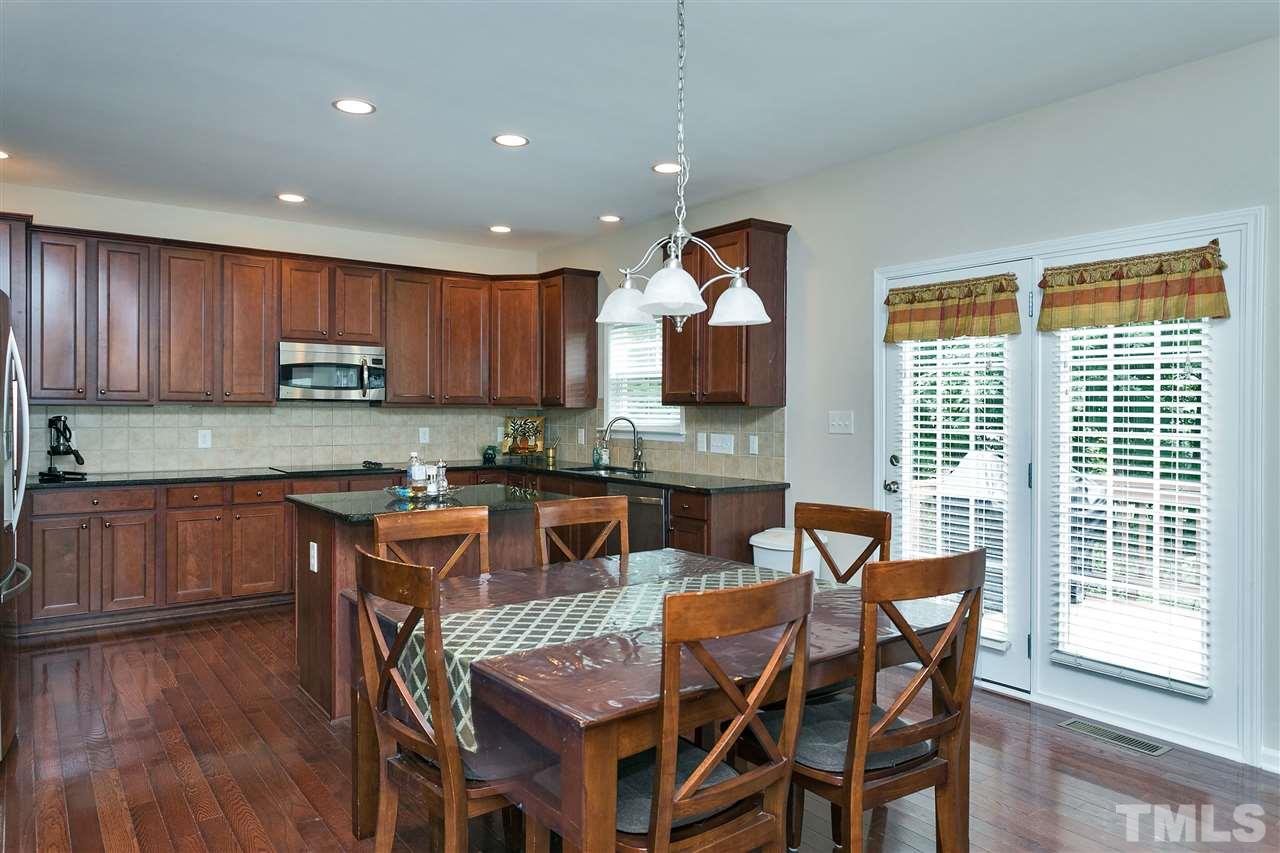 119 Key Biscayne Court Raleigh, NC 27603 - Photo 6 of 24 a kitchen with a dining table chairs and granite counter tops