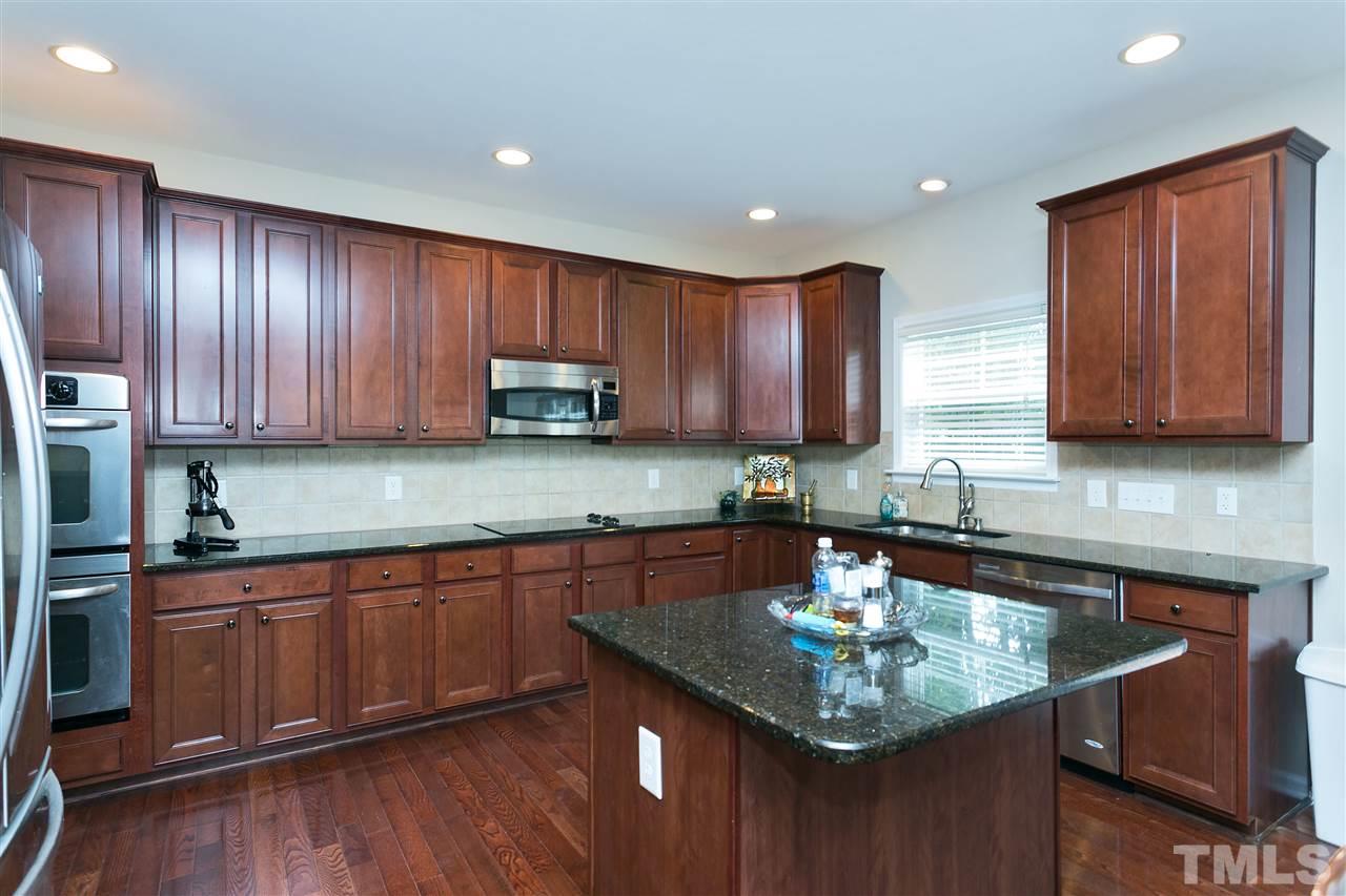 119 Key Biscayne Court Raleigh, NC 27603 - Photo 8 of 24 a kitchen with kitchen island granite countertop wooden cabinets a sink and dishwasher