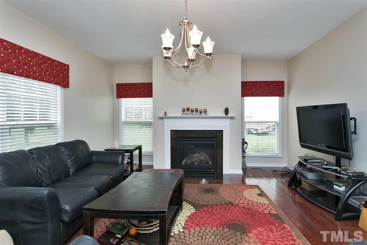 119 Key Biscayne Court Raleigh, NC 27603 - Photo 9 of 24 a living room with furniture a flat screen tv and a fireplace