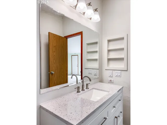 a bathroom with a granite countertop sink and a mirror