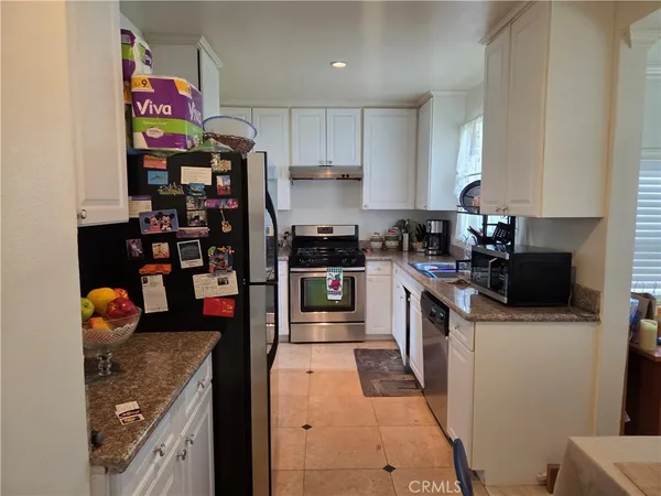 a kitchen with stainless steel appliances granite countertop a refrigerator and a stove top oven
