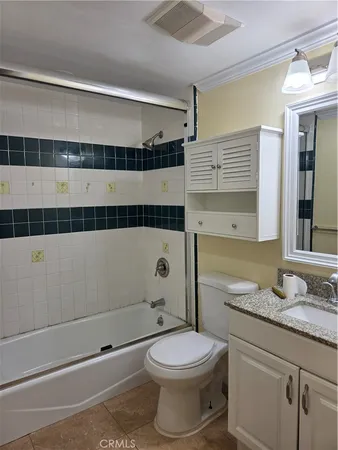 a bathroom with a granite countertop sink a toilet and shower