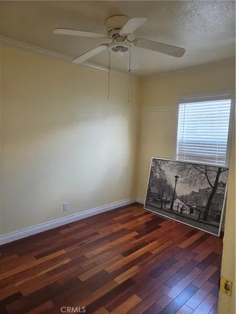 a room with wooden floor and ceiling fan