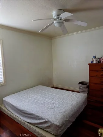 a bedroom with a bed and a chandelier fan
