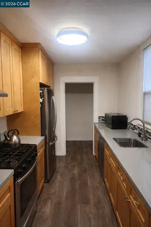 a kitchen with a sink a refrigerator and cabinets