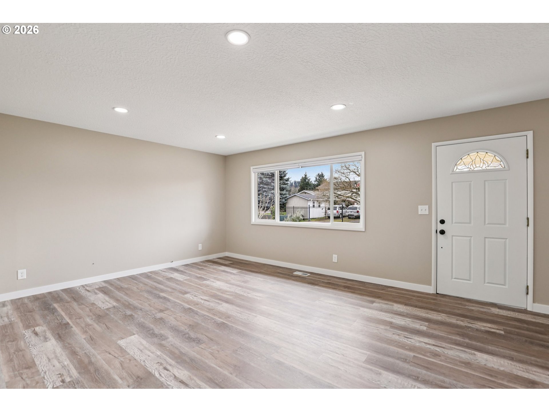 18021 Southeast Mill Court Portland, OR 97233 - Photo 4 of 36 an empty room with wooden floor and windows