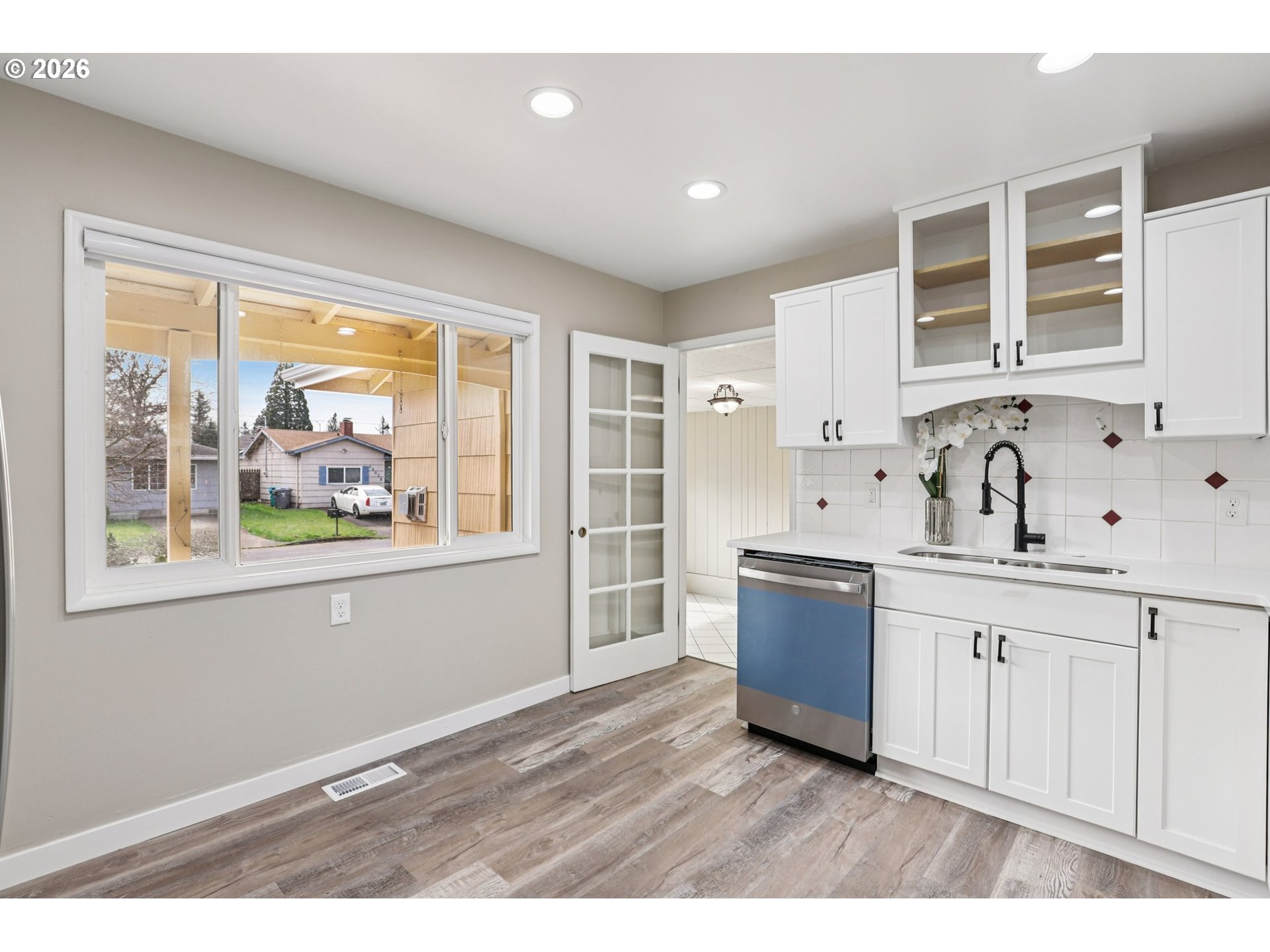 18021 Southeast Mill Court Portland, OR 97233 - Photo 8 of 36 a kitchen with wooden floors and white cabinets