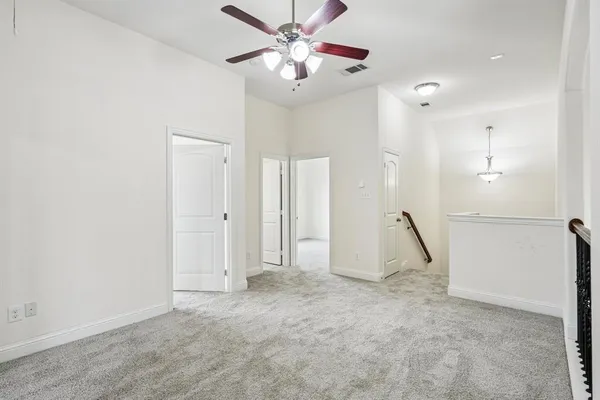a view of a room with wooden floor and a ceiling fan