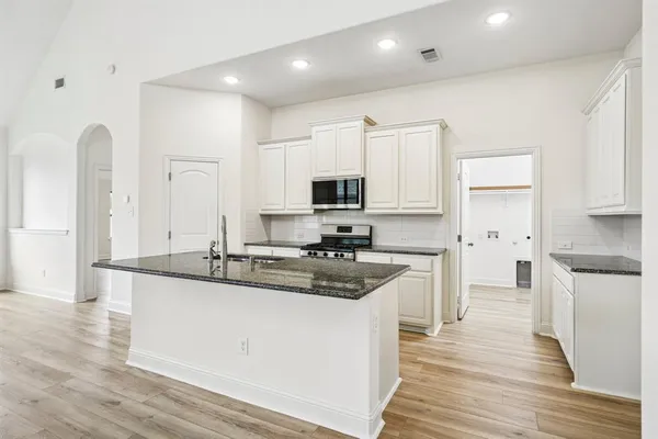 a kitchen with stainless steel appliances granite countertop a sink stove and refrigerator
